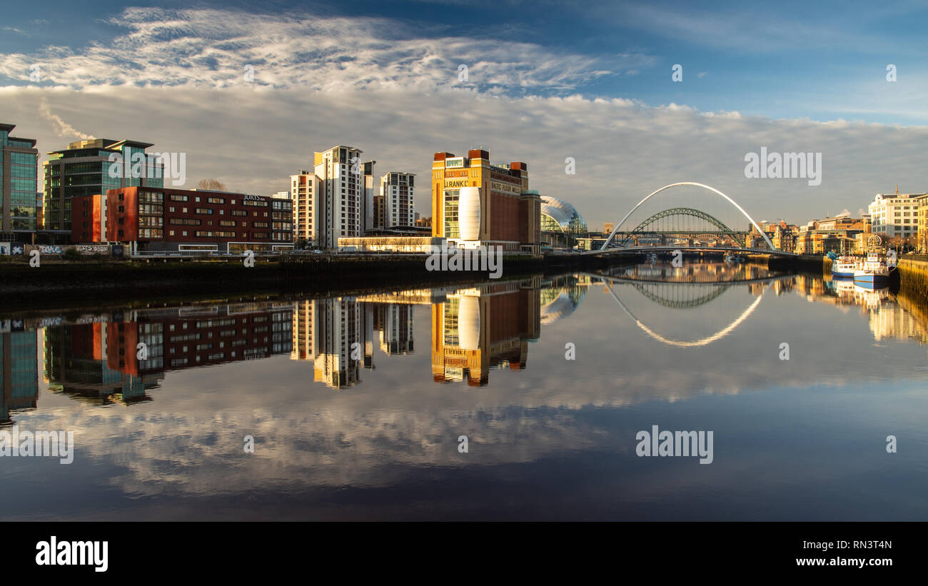 Gateshead, England, Großbritannien - Februar 5, 2019: Dämmerung fällt Licht auf die ikonischen Ostsee Mühlen Gebäude, Tyne Bridge und Gateshead Millennium Bridge auf Stockfoto