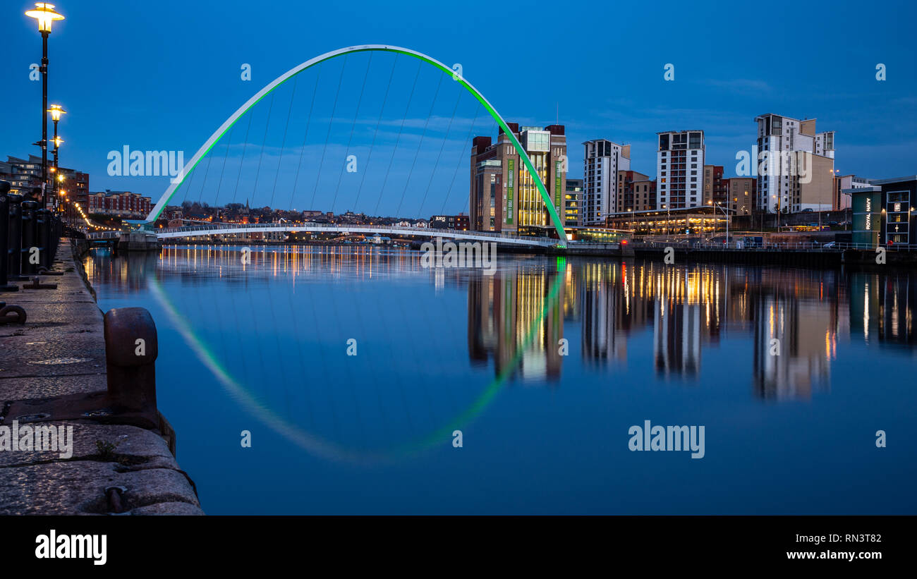 Gateshead, England, Großbritannien - Februar 6, 2019: der Gateshead Millennium Bridge und BALTIC Mühlen in der Dämmerung auf den Fluss Tyne Kais beleuchtet werden. Stockfoto