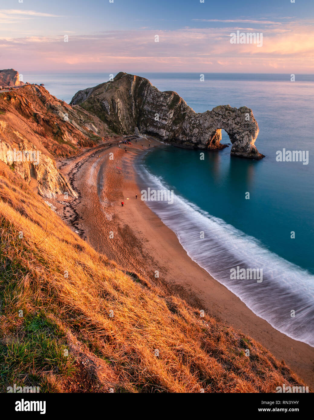 Dorset, England, Großbritannien - 27 Dezember, 2018: Die Menschen laufen am Strand entlang und clifftop Coast Path at Durdle Door auf in Dorset Jurassic Coast. Stockfoto