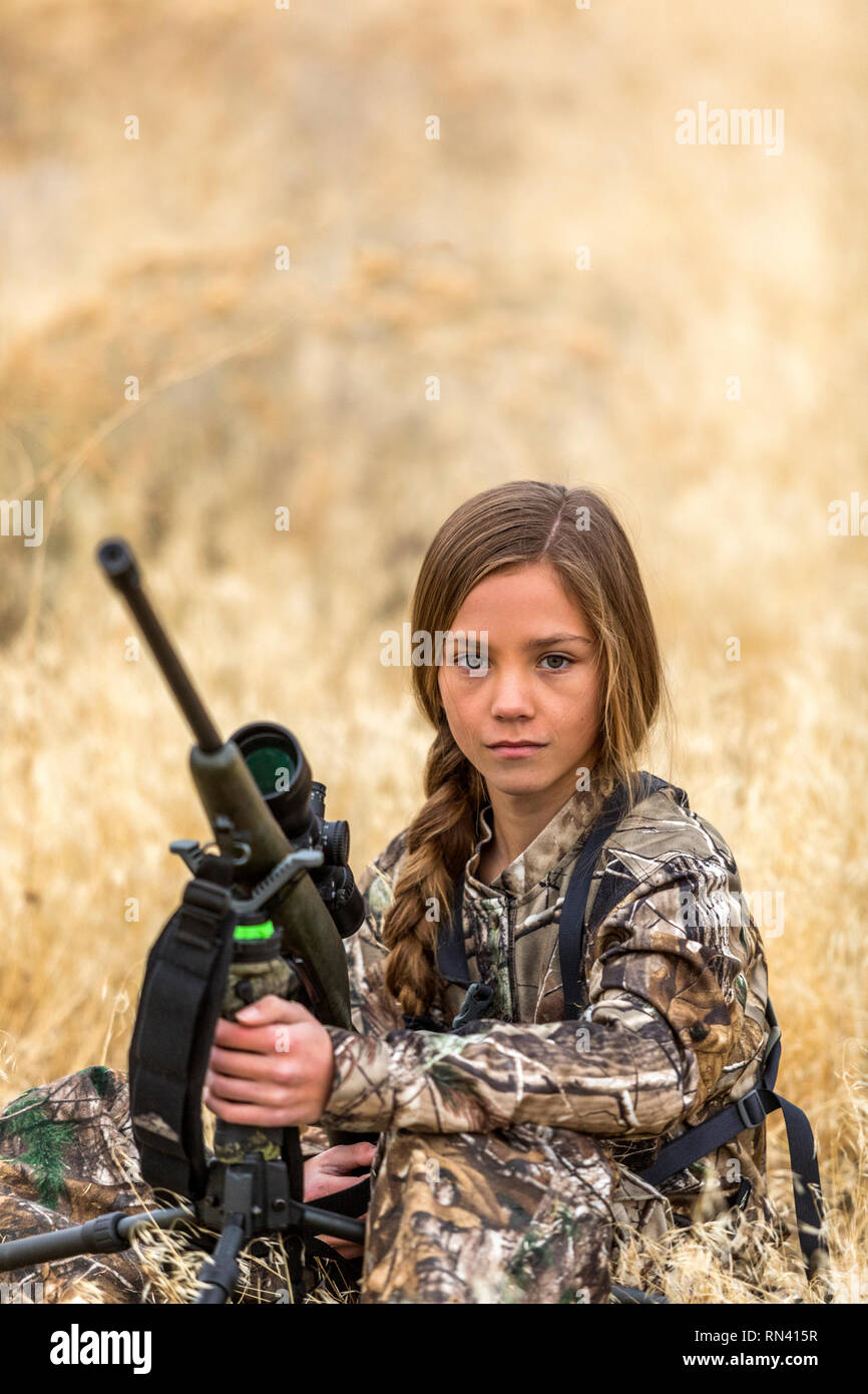 Mädchen hocken mit Jagdgewehr Stockfoto