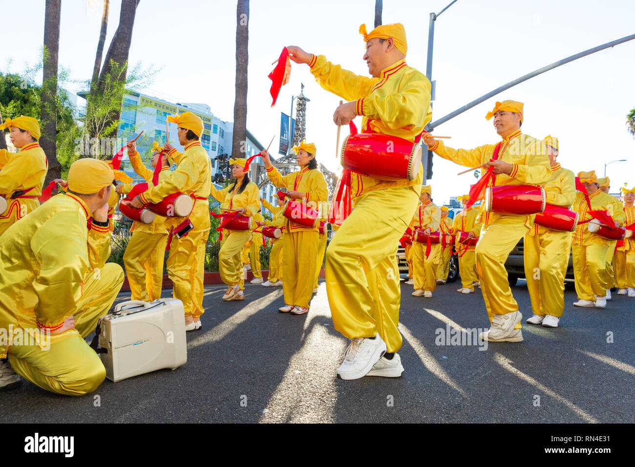 Falun Gong Anhänger in leuchtend gelben Uniformen in Christmas Parade auf dem Hollywood Boulevard in Los Angeles, Kalifornien marschieren. Stockfoto