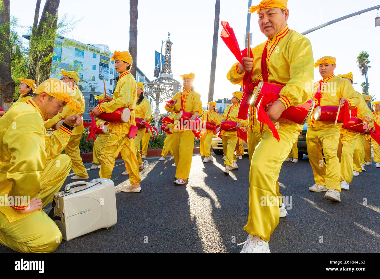 Falun Gong Anhänger in leuchtend gelben Uniformen in Christmas Parade auf dem Hollywood Boulevard in Los Angeles, Kalifornien marschieren. Stockfoto