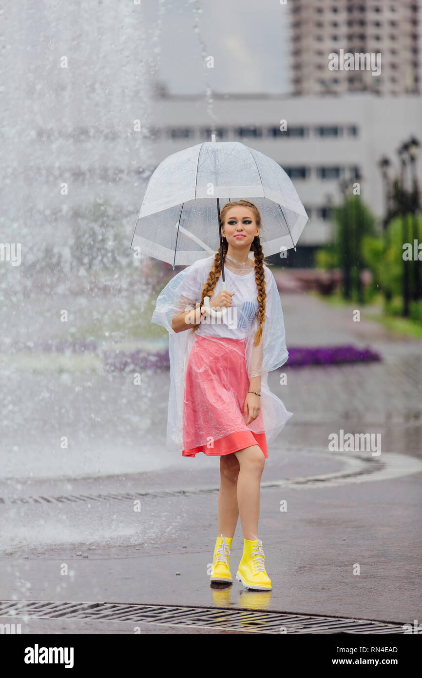 Junge hübsche Mädchen mit zwei Litzen in den gelben Stiefeln und mit