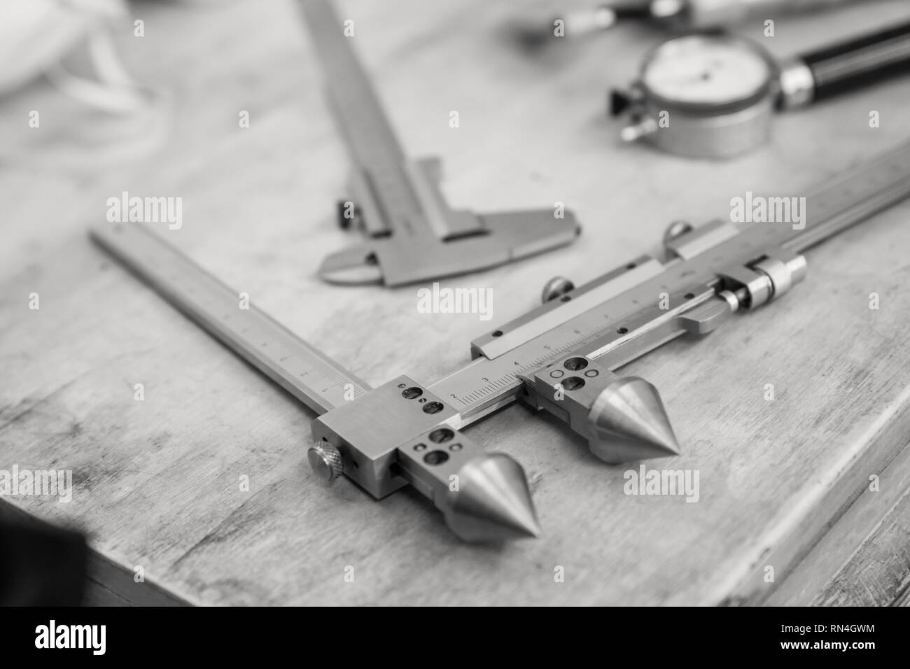 Metall Messgeräte auf einem Holztisch. Produkt Qualitätskontrolle. Schwarz und Weiß. Stockfoto