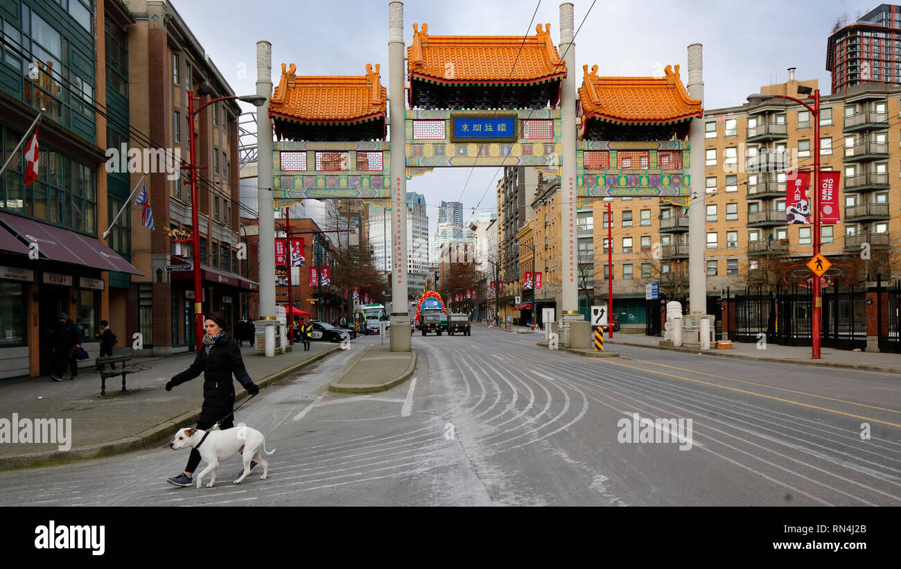 Eine Person, die mit einem Hund in der Nähe von Vancouver Chinatown Millenium Gate, Vancouver, British Columbia, Kanada spaziert Stockfoto