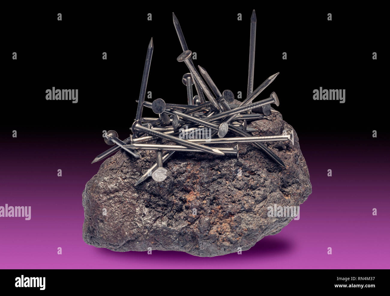 Magnetit zieht eiserne Nägel Stockfoto