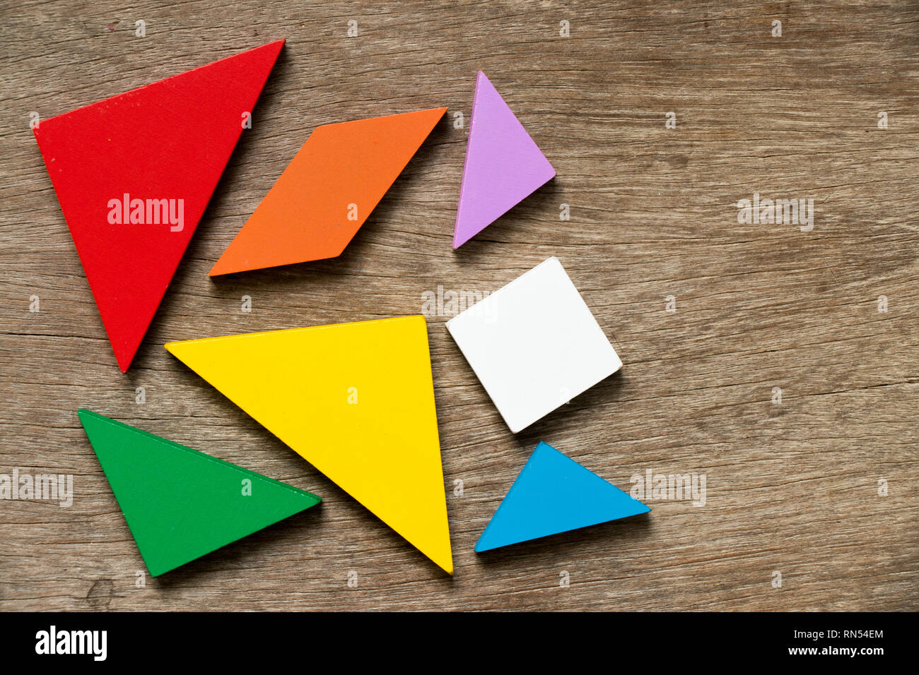 Bunte tangram Puzzle warten auf Holz Hintergrund zu entwickeln. Stockfoto