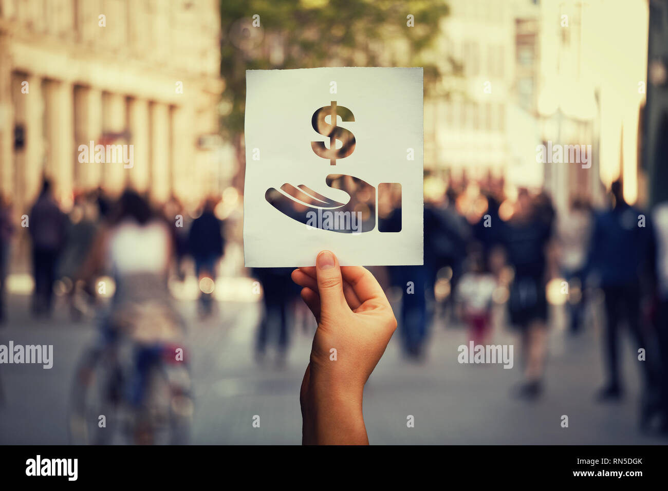 Stop Korruption globales Thema. Hand hält ein Blatt Papier geben Bestechungsgeld Symbol über überfüllten Stadt Straße Hintergrund. Regierung Bestechung als Ursache von Pover Stockfoto