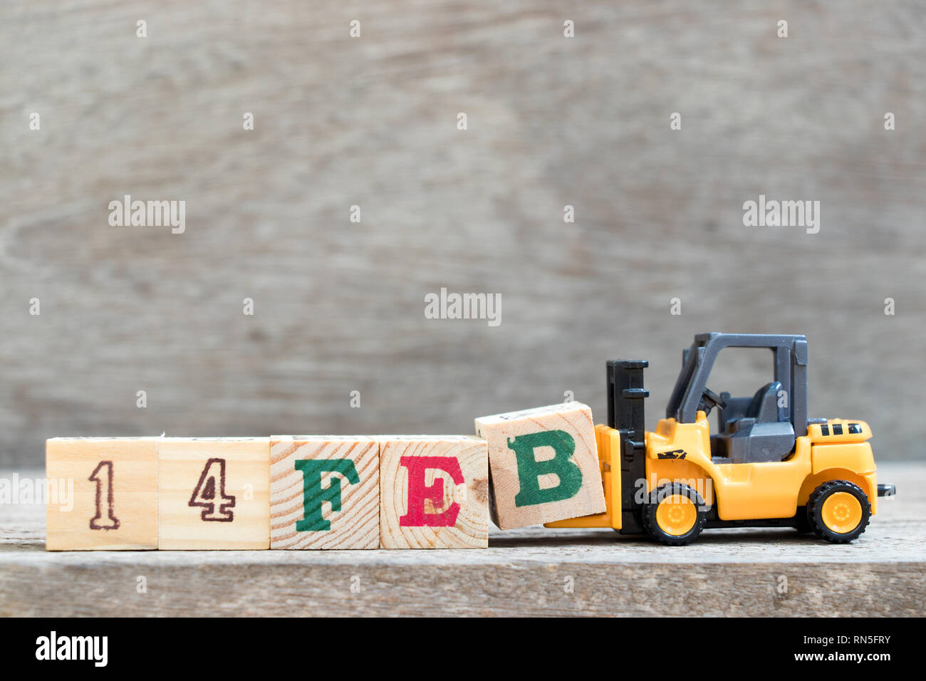 Spielzeug Gabelstapler halten schreiben Block B zu Wort vervollständigen 14 Feb auf Holz Hintergrund (Konzept für den 14. Februar, dem Valentinstag ist Tag) Stockfoto