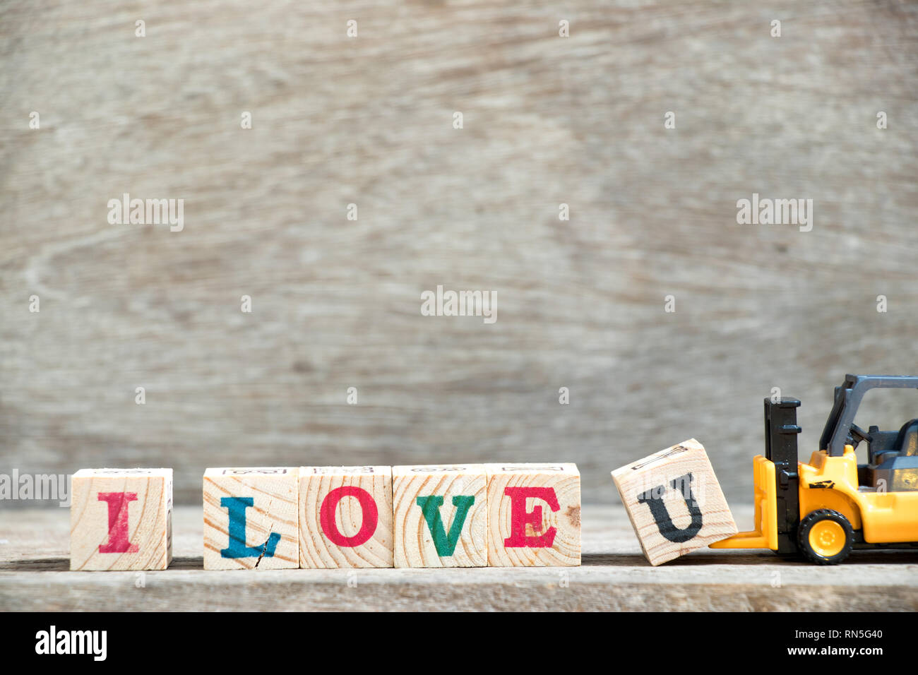 Spielzeug Gabelstapler Buchstaben gedrückt. block u Wort I love u auf Holz Hintergrund abzuschließen Stockfoto