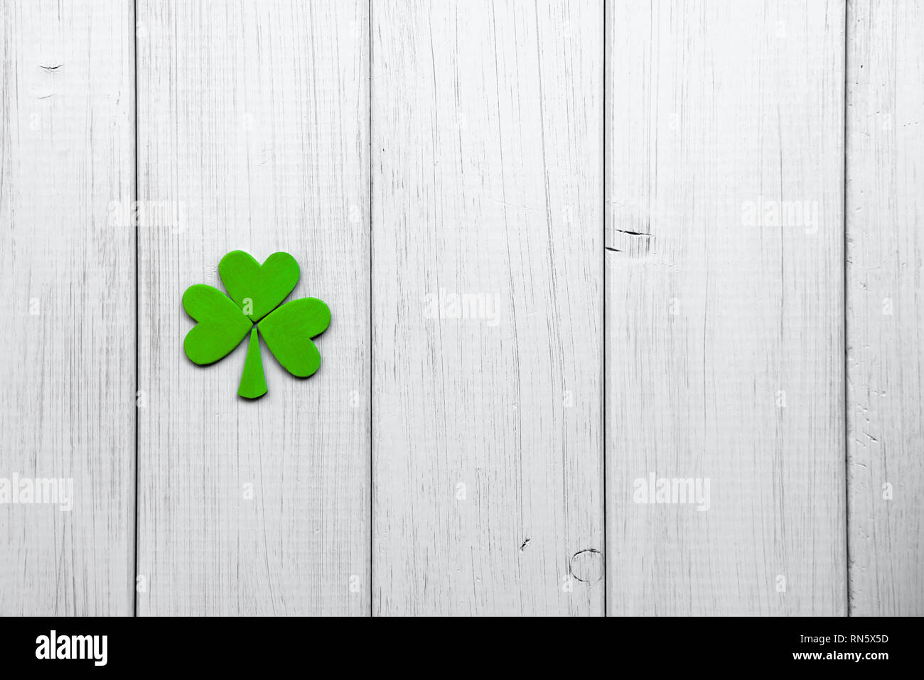 Happy St. Patrick's Day. Dekorationen in Form von shamrock Blätter auf einem grauen Hintergrund Holz Stockfoto