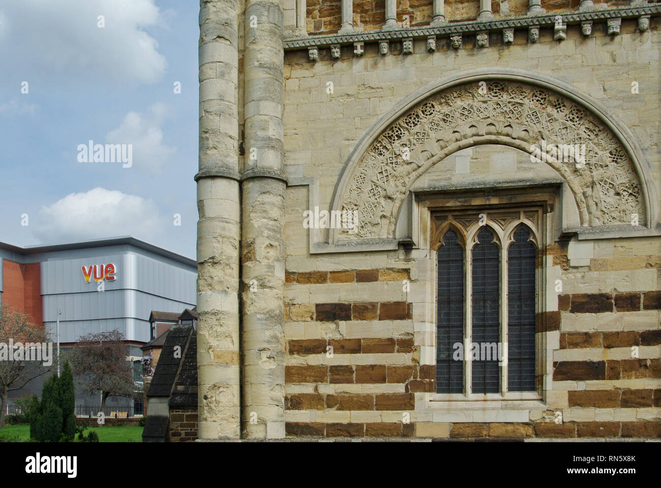 Alte und Moderne, die normannische Turm von St. Petri Kirche und im Hintergrund die Fassade des Vue Cinema; Northampton, Northamptonshire, Großbritannien Stockfoto