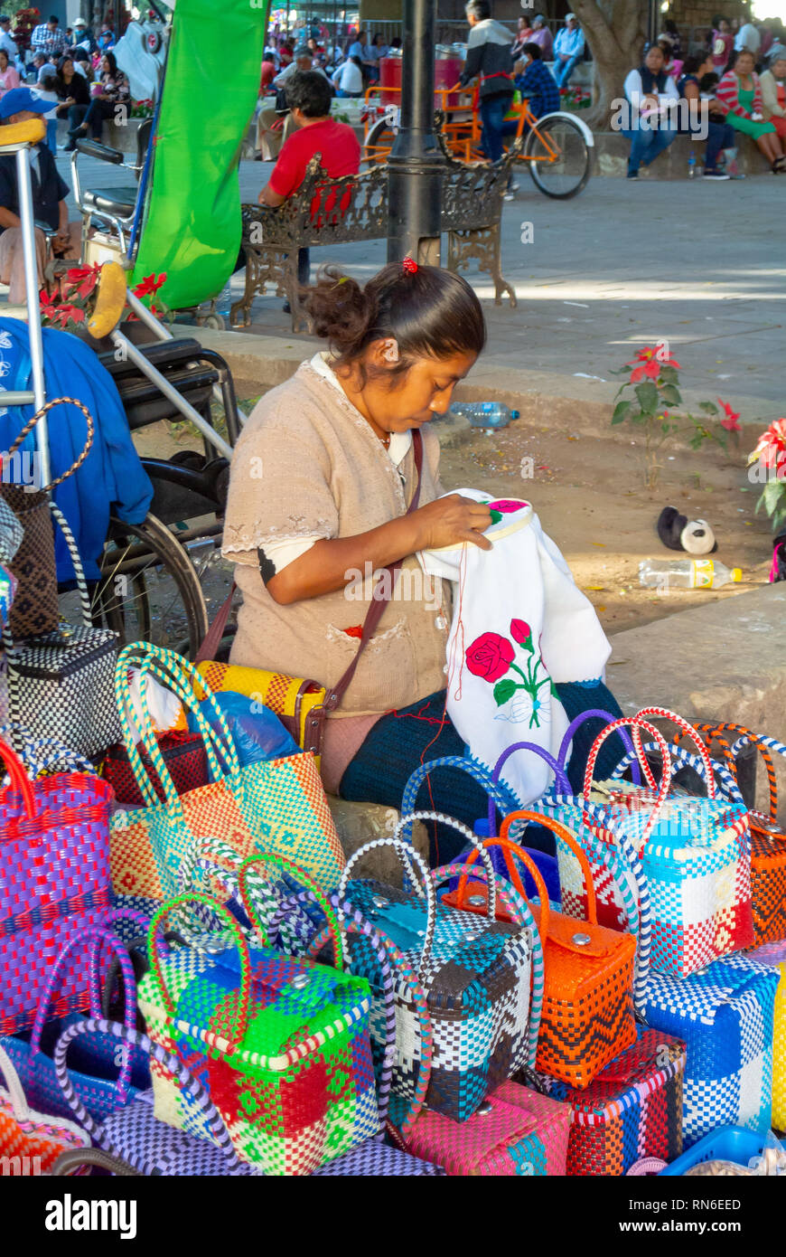 Lokale Frau tun Stickerei am Stand von Markt, Oaxaca, Mexiko Stockfoto