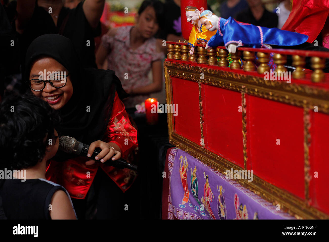 Ein Kind wird betrachtet die Interaktion mit einem potehi Puppe während der Durchführung während des Festivals an Dhanagun Tempel. Traditionelle Puppentheater werden gefährdet, die potehi Puppenspiel im Bogor Straßenfeste 2019 Serie die Erhaltung der traditionellen Kunst und Kultur unterstützt. Stockfoto