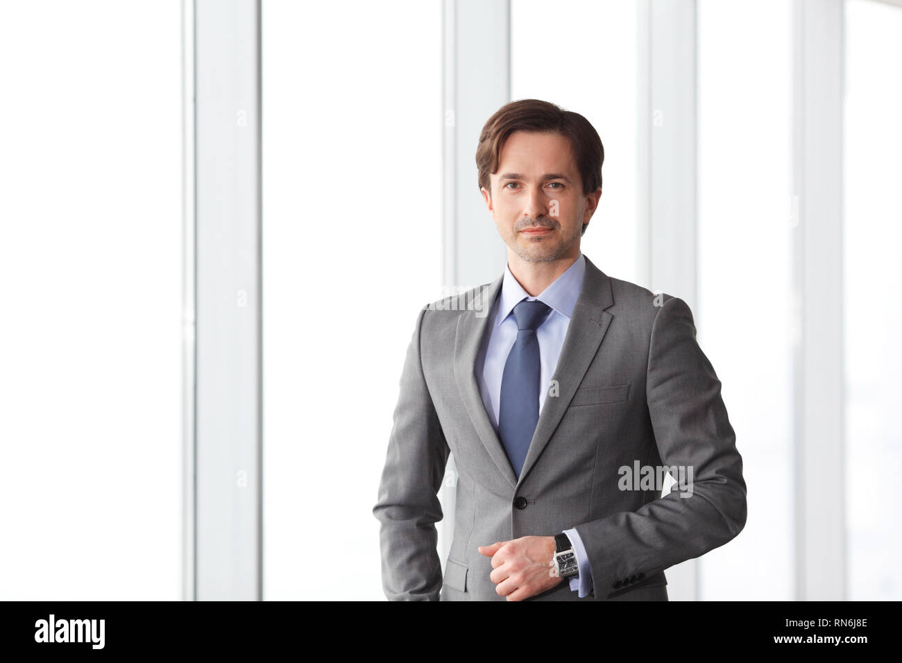 Porträt der schönen Geschäftsmann stehen in der Nähe von Windows im Büro Stockfoto