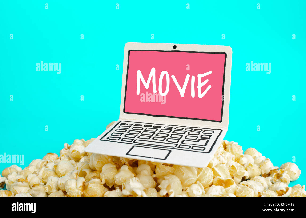 Live Streaming Film Konzepte mit Text auf Papier kunst Laptop und Pop Corn auf pastellfarbenen Hintergrund Stockfoto