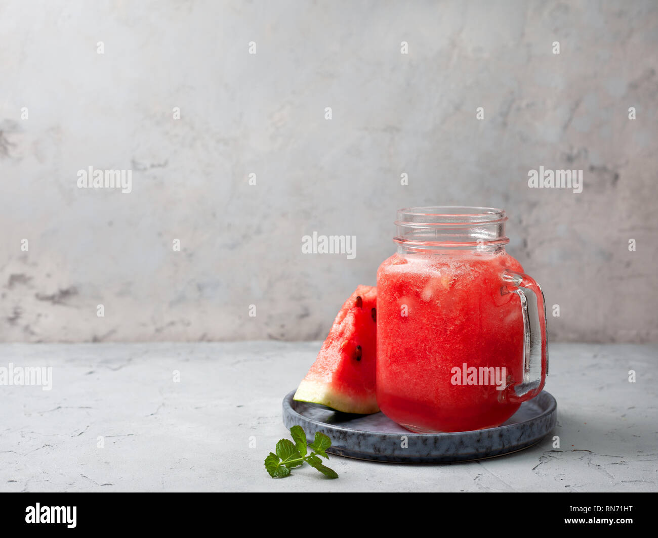 Frische Wassermelone in einem Marmeladenglas auf grauem Beton Hintergrund Stockfoto