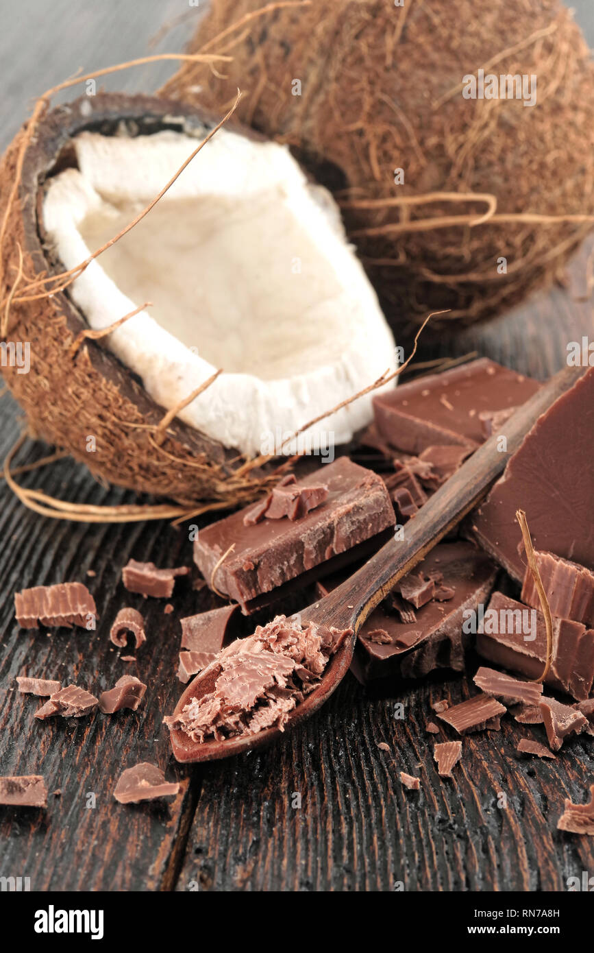 Gebrochene dunkle Schokolade und schokolade Flocken auf einem Holztisch Stockfoto