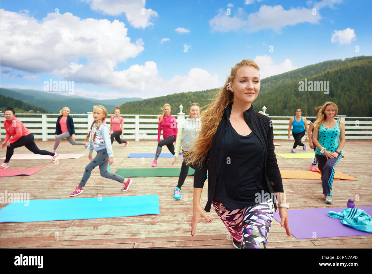 Professionelle Trainer Ausbildung fitness, zeigt sich bewegt. Schöne Frau coaching fitness Gruppe für frische Luft. Mädchen und Frauen tragen in Sportkleidung, verdrehen Übungen. Stockfoto