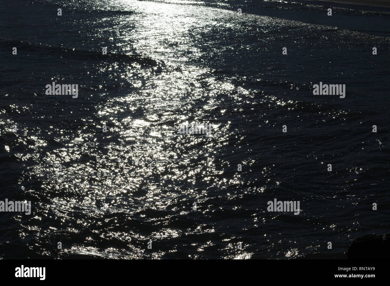 Meer Wasser langsam Wellen unter den letzten Sonnenlicht produziert schöne Muster. Stockfoto