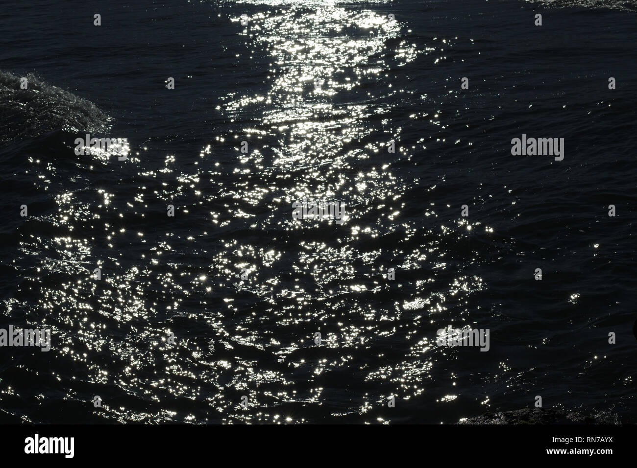 Meer Wasser langsam Wellen unter den letzten Sonnenlicht produziert schöne Muster. Stockfoto