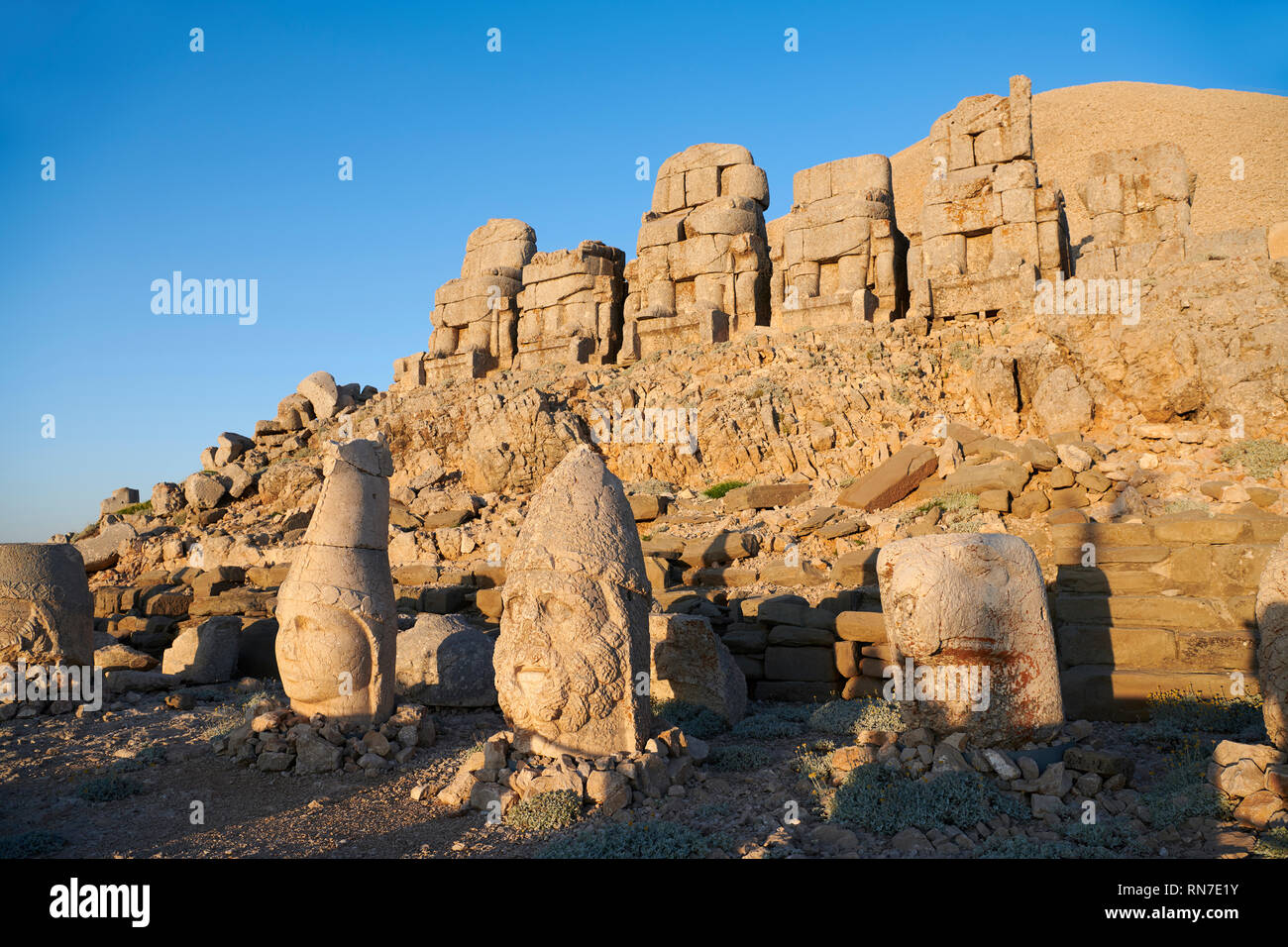Statue Köpfe, von rechts, Adler, Herekles & Apollo mit kopflosen Sitzstatuen vor der steinernen Pyramide, Ost Terrasse, Berg Nemrut oder Nemrud Stockfoto