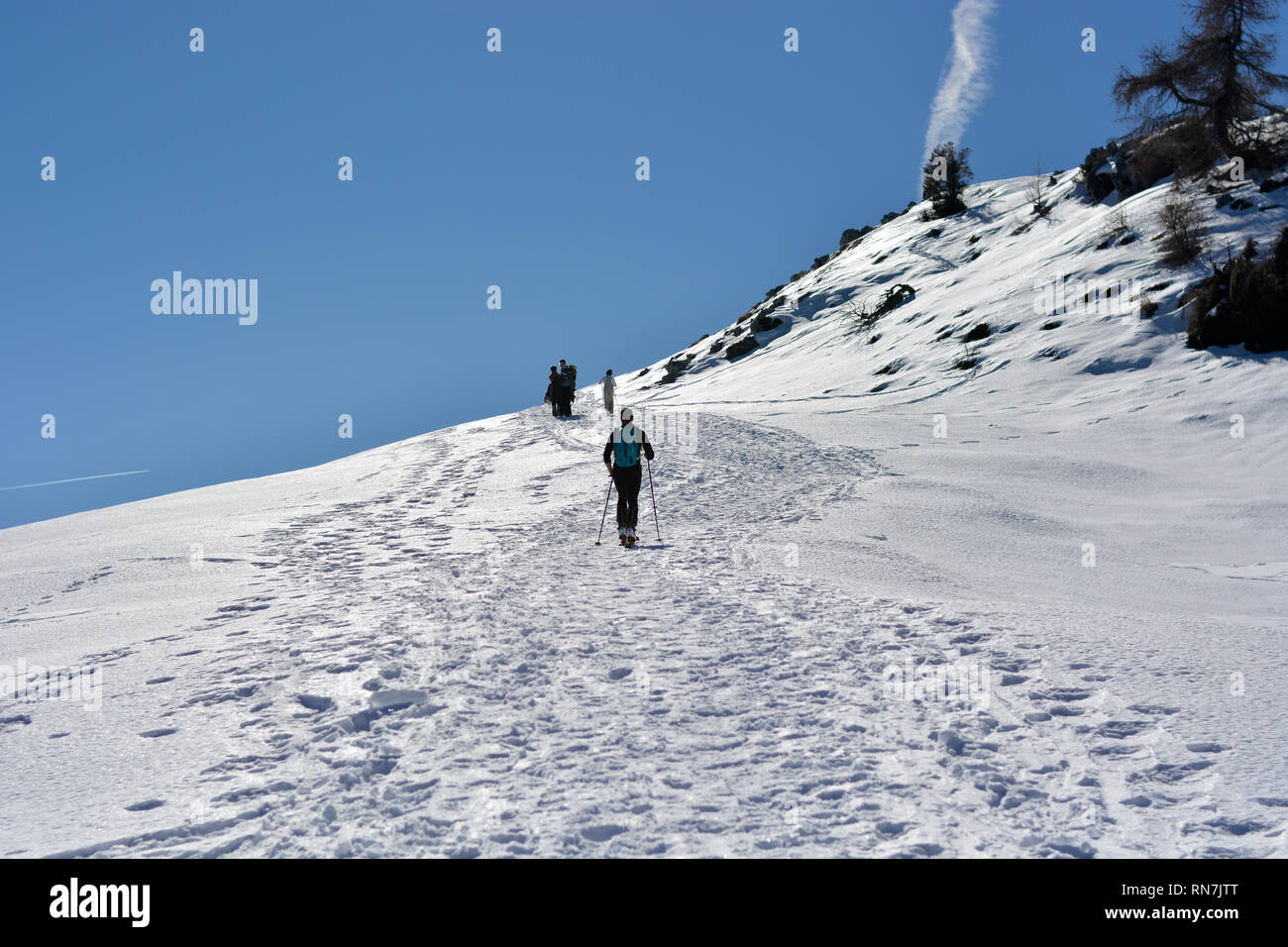Klettern die Berge mit den Skiern Stockfoto
