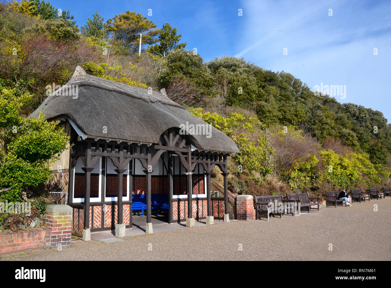 Bänke in einem strohgedeckten Unterkunft, mit Blick auf das Meer, die Promenade, an der Küste von Eastbourne Eastbourne, England, Großbritannien Stockfoto