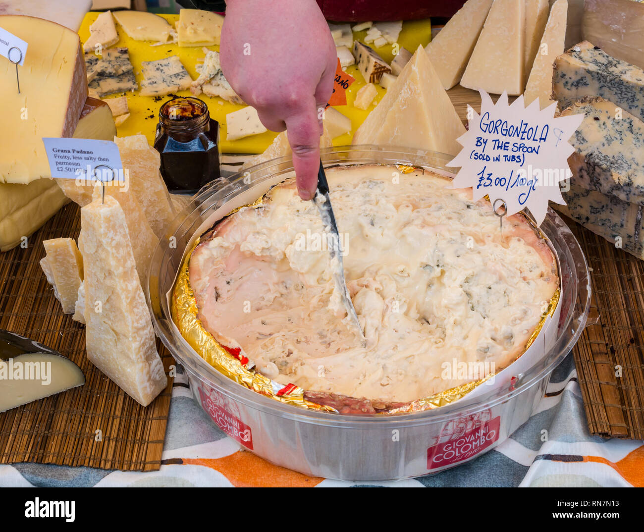 Hand scopping runny Gorgonzola käse, käse Stall, Leith, Dock Street, Edinburgh, Schottland, Großbritannien Stockfoto