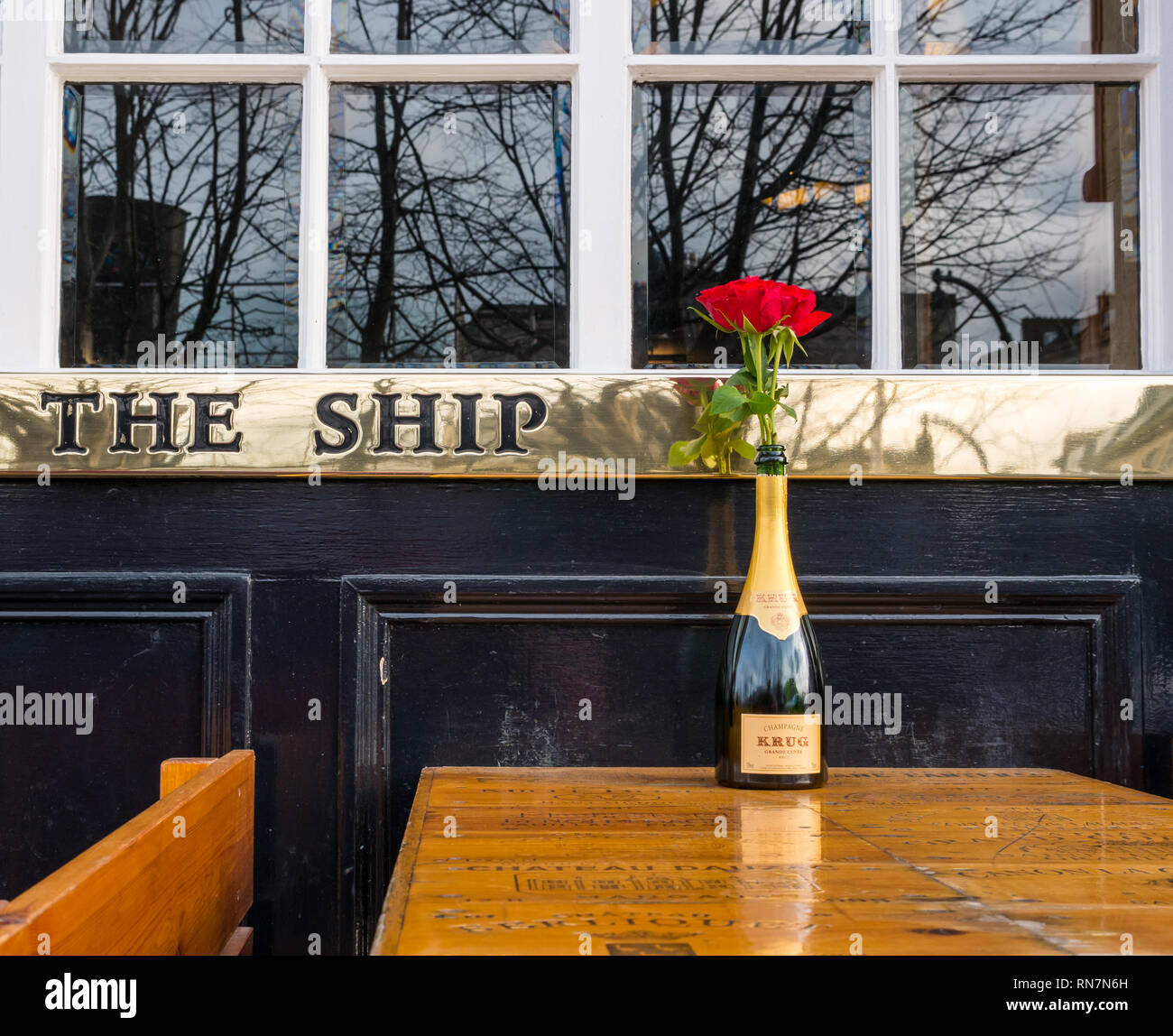 Krug Champagner Flasche mit rote Rose auf außerhalb Pflaster Tabelle, Schiff am Ufer Restaurant mit Messing name, Leith, Edinburgh, Schottland, Großbritannien Stockfoto