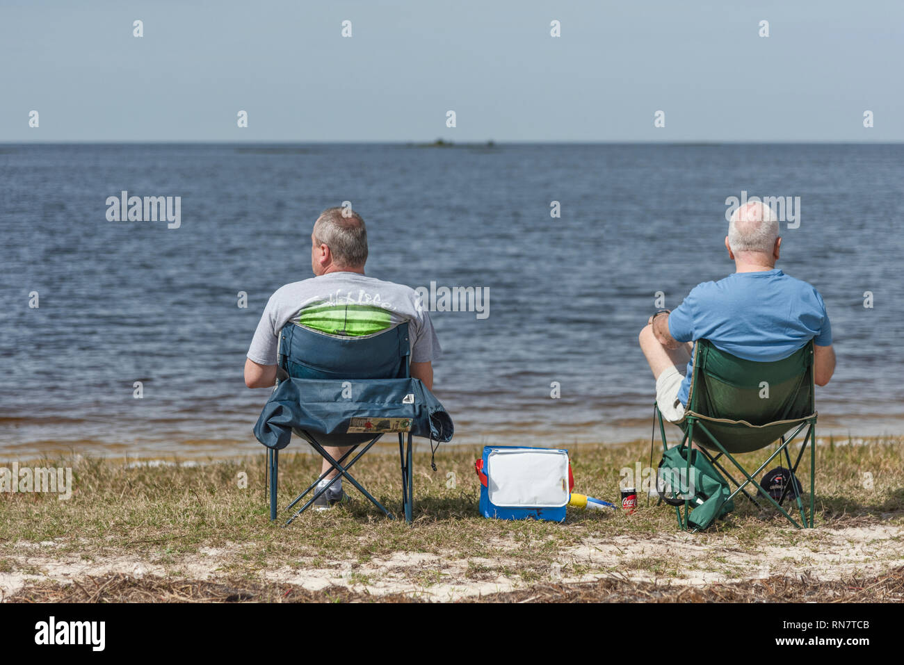 Zwei Männer in die Stühle an Vogel Creek Strand in Yankeetown, Florida genießen der Gulf Coast Ocean View. Stockfoto