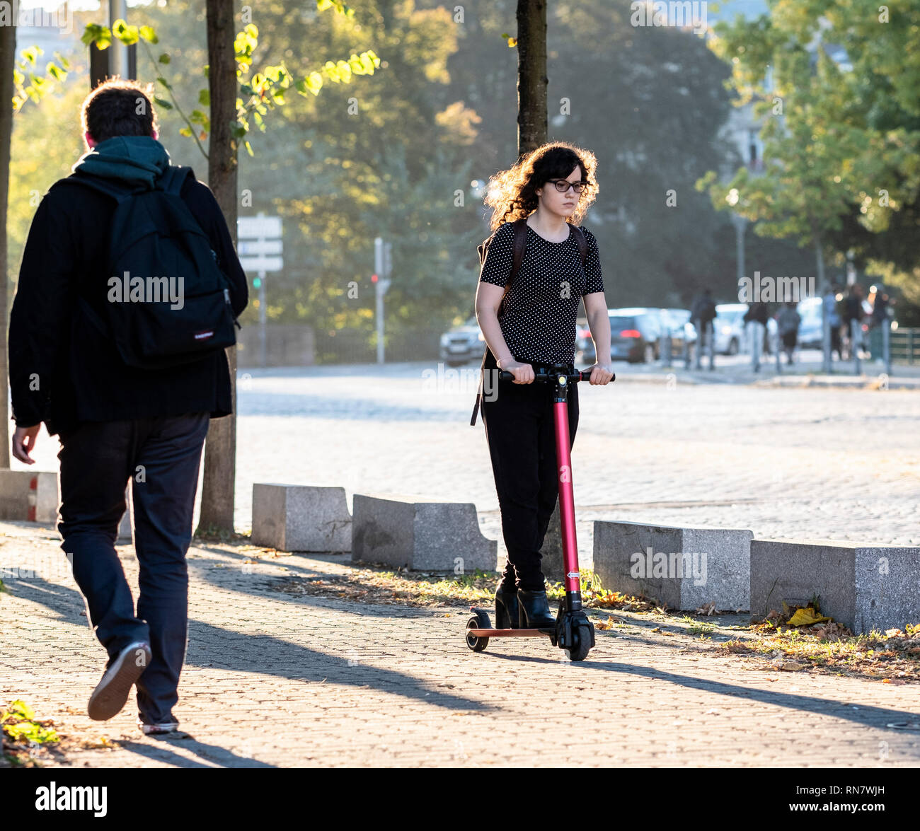 Straßburg, Elsass, Frankreich, junge Frau reiten Ihr dockless Elektroroller auf Pflaster, Stockfoto