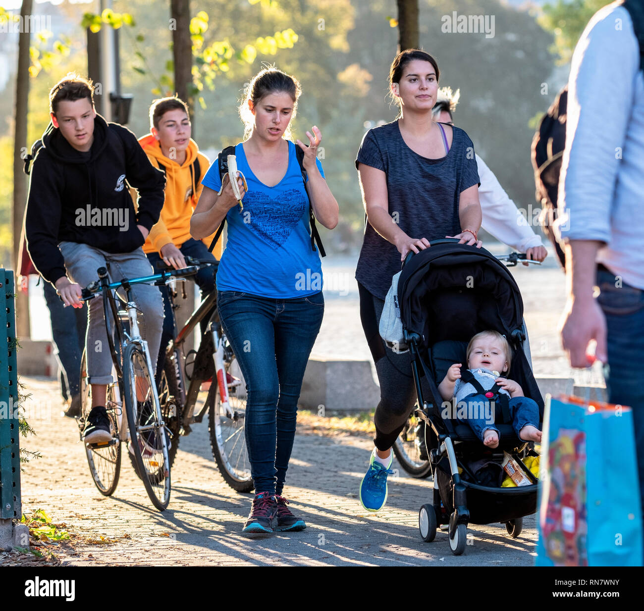 Straßburg, Elsass, Frankreich, Frauen zu Fuß auf Bürgersteig, Kinderwagen und jugendliche Jungen Radfahren auf Pflaster, Stockfoto