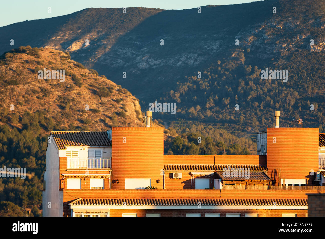 Apartament Bausteine in Spanien bei Sonnenuntergang mit Bergen im Hintergrund Stockfoto