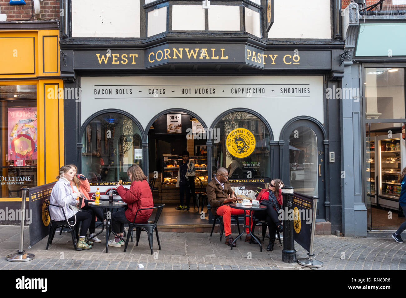 Die West Cornwall Pasty Co Cafe auf Peascod Street, Windsor, Berkshire, Großbritannien. Die Leute draußen Sitzen und Essen an Tischen und Stühlen zur Verfügung. Stockfoto