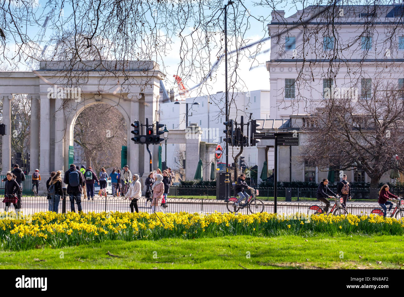 LONDON, UK, 21. März 2018: Personen, die einen sonnigen Tag in London, auf dem Fahrrad oder zu Fuß im Hyde Park. Stockfoto