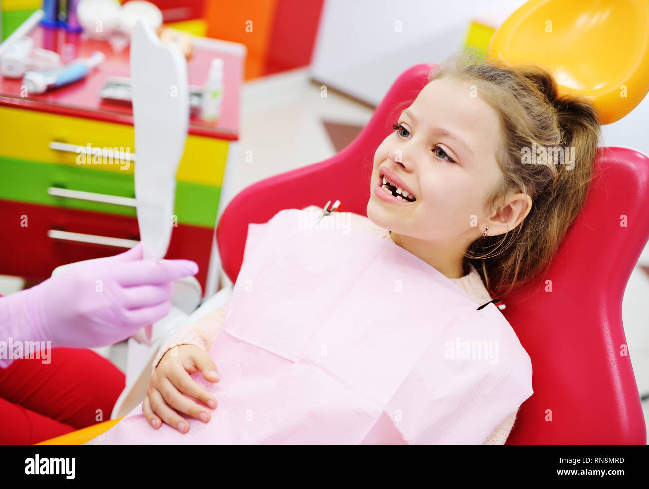 Kid girl Vorschüler mit keine vordere Milchzähne lächelnd sitzen in den zahnmedizinischen Stuhl. Stockfoto