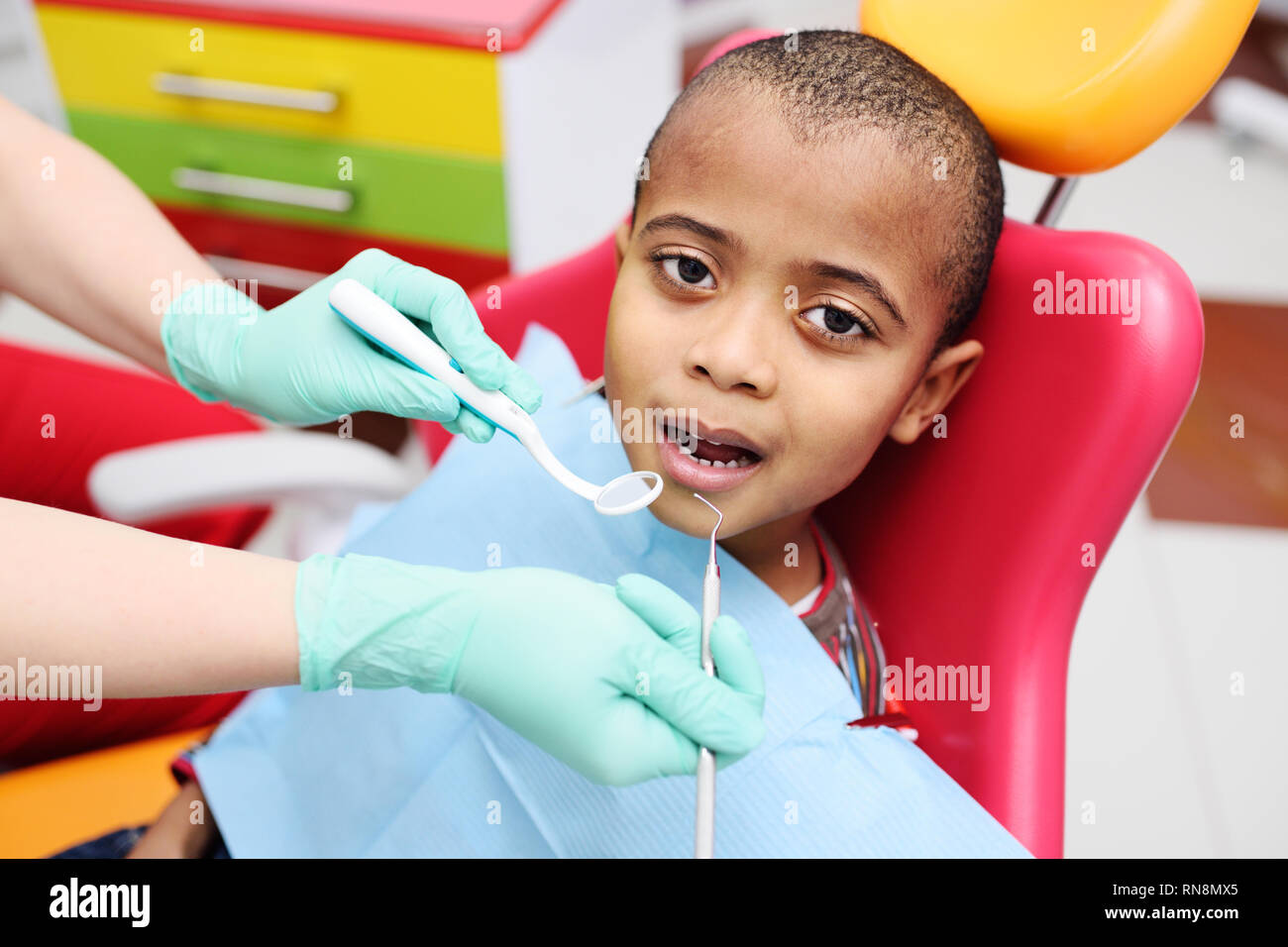 Cute schwarz baby junge afrikanische amerikanische lächelnd sitzen in den zahnmedizinischen Stuhl Stockfoto