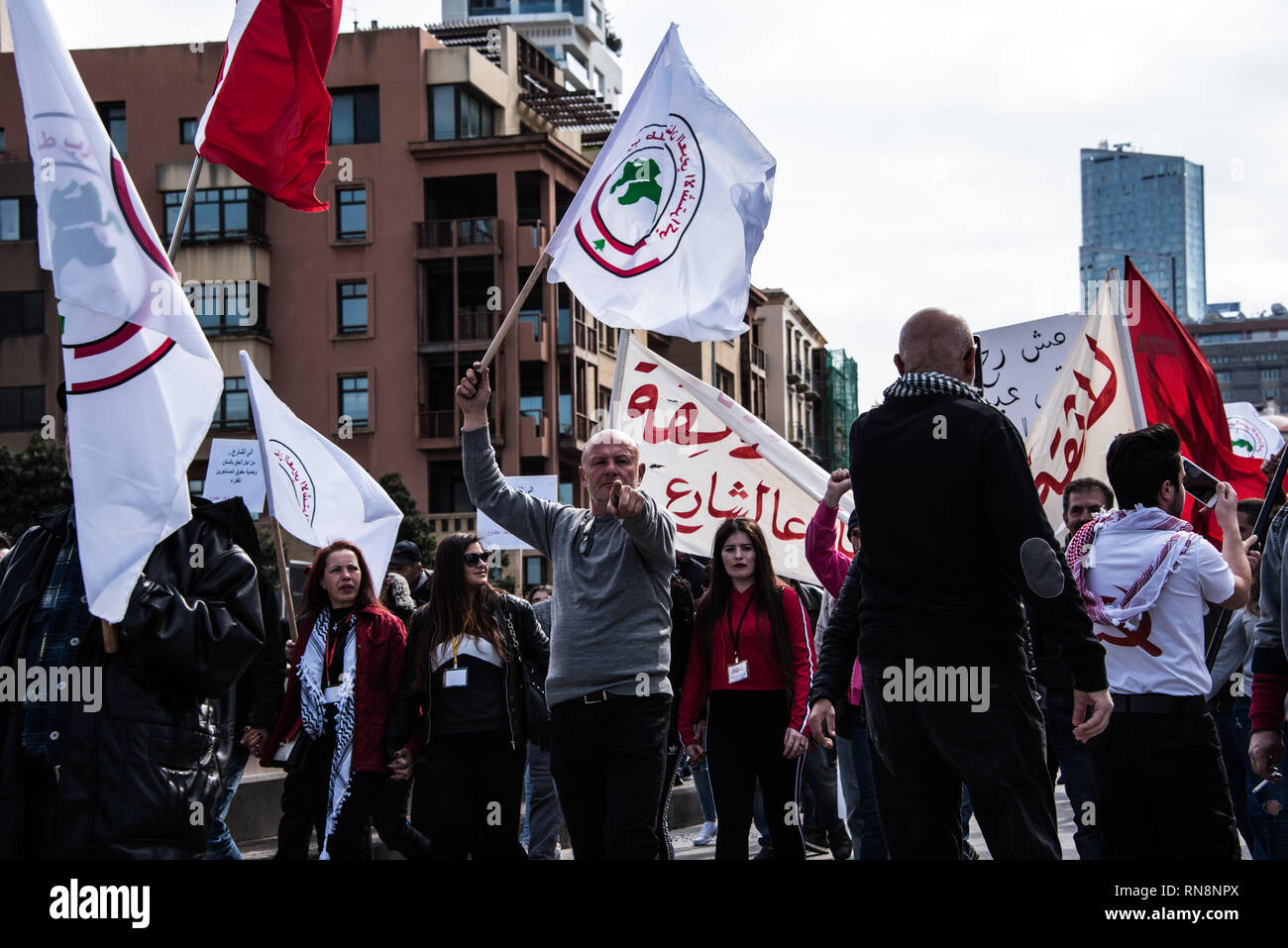 Ein Mann gesehen, der auf der Kamera mit einer Flagge während des Protestes. Bürger marschierten durch Beirut in einem Protest gegen die wirtschaftliche Ungleichheit und erschreckende Mangel an grundlegenden öffentlichen Dienstleistungen im Libanon. Aufruf für eine nicht-säkularen Regierung Struktur, effiziente öffentliche Dienstleistungen und ein Ende der Korruption, sagen Sie, dass Sie alle zwei Wochen kommen zur friedlichen Druck auf einem Status quo, unerträglich für zu lang wurde. Beirut, Libanon. Stockfoto