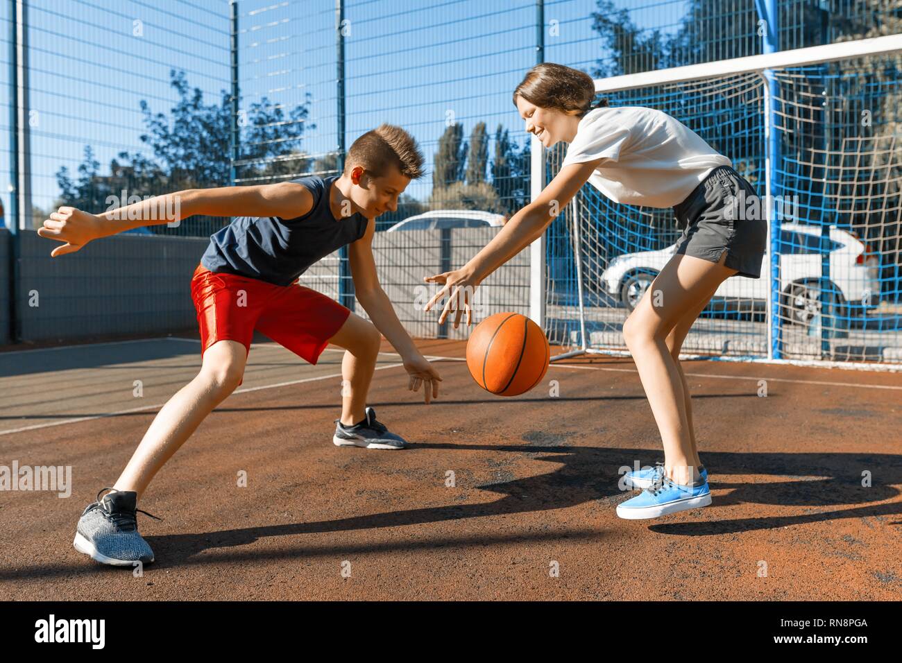 Streetball Basketball Spiel mit zwei Spielern, jugendliche Mädchen und junge mit Ball, outdoor Stadt Basketballplatz Stockfoto