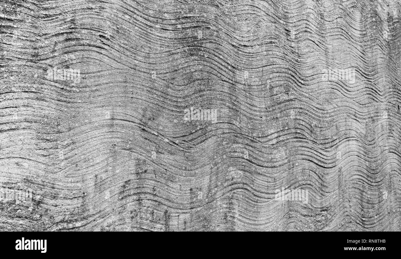 Abstrakte unregelmäßige wellige Linien in Zement gerenderte Wand. Stockfoto