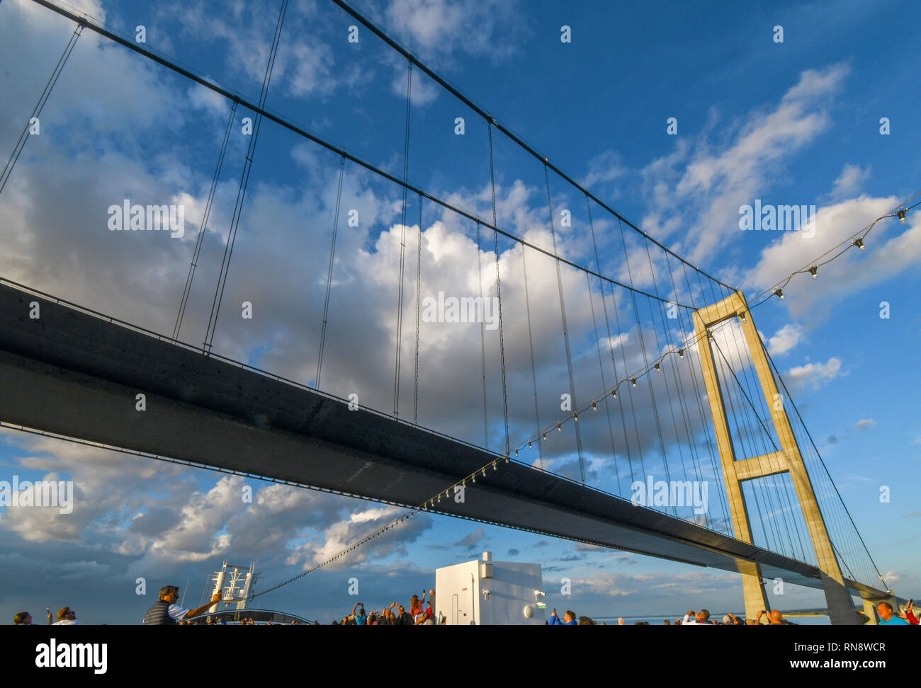 Touristen heben ihre Kameras und Handys zu Fotografieren die Øresund-Brücke als Ihre Kreuzfahrt Schiff fährt unter der Eisenbahnbrücke und Autobahnbrücke. Stockfoto