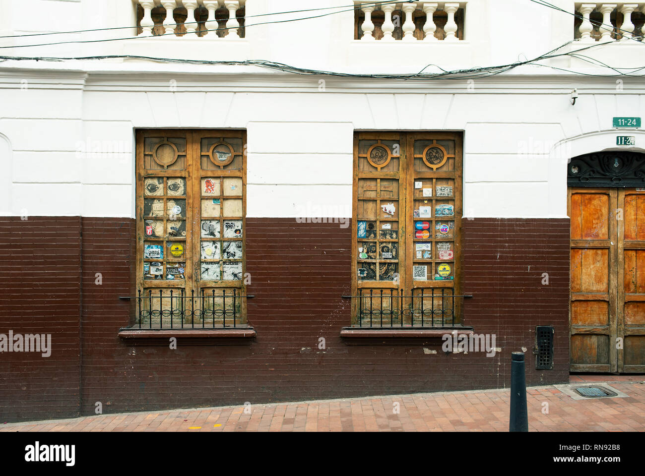 Elegante koloniale Fassade mit aus Holz geschnitzten Fenstern - durch Aufkleber verwöhnt. La Candelaria. Bogota, Kolumbien. Sep 2018 Stockfoto