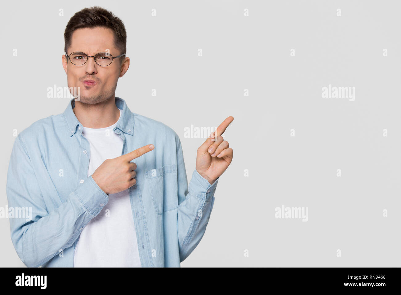 Verwirrt verwirrt Mann Pointing Finger an Copyspace Gefühl misstrauisch Stockfoto