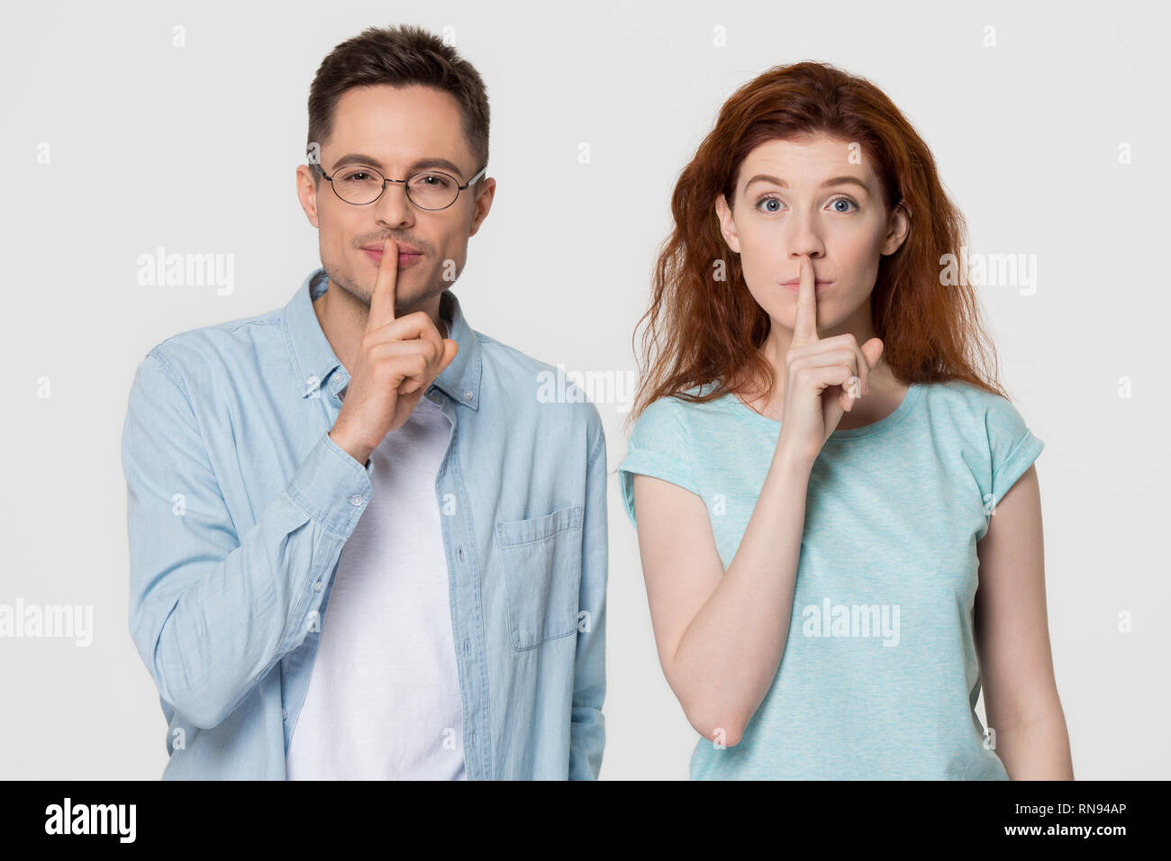 Junge mute Paar hält die Finger auf den Mund halten Sie es ruhig Stockfoto