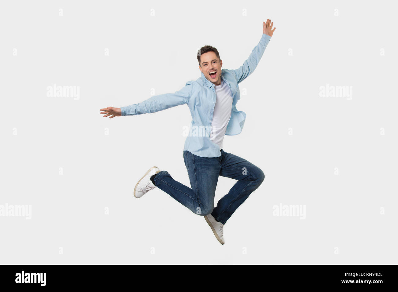 Happy fröhlicher junger Mann springen Gefühl Freude auf Hintergrund isoliert Stockfoto