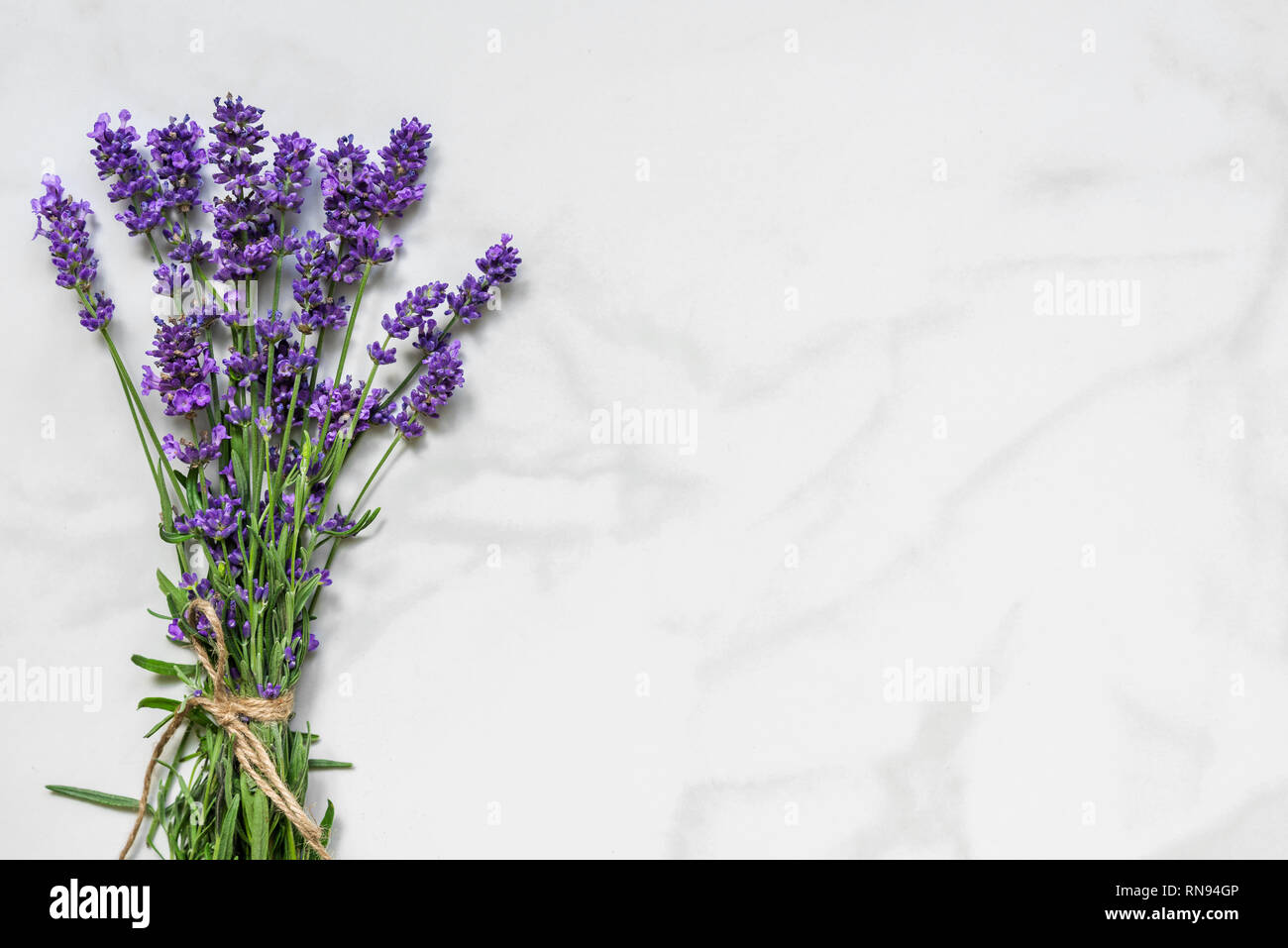 Schöne Lavendel Blumen Blumenstrauß auf weißem Marmor Tisch mit Platz für Ihren Text kopieren. top anzeigen. Flach. Hochzeit oder Tag der Frauen Hintergrund Stockfoto