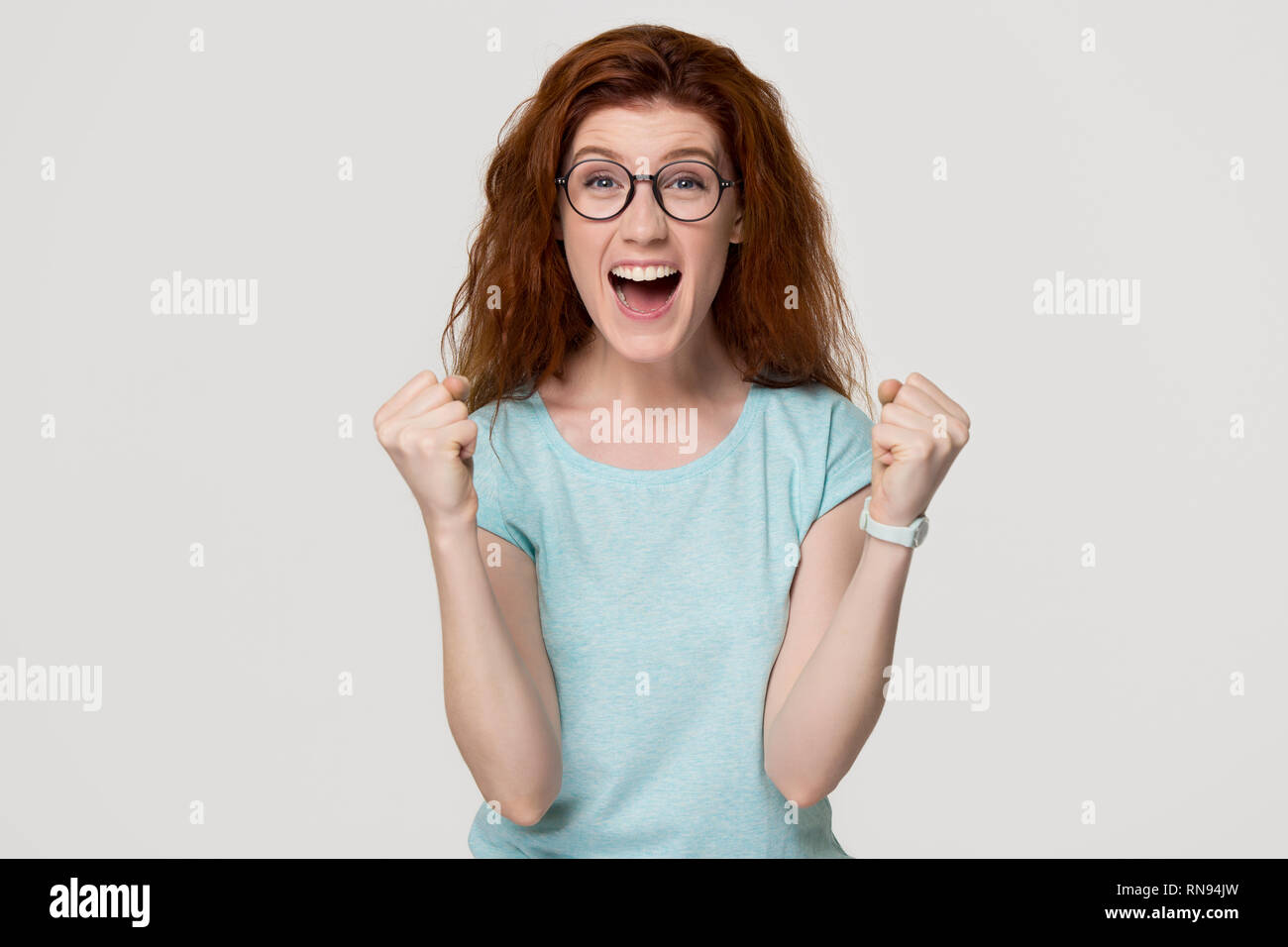 Aufgeregt überglücklich junge rothaarige Frau glücklich an Kamera Stockfoto