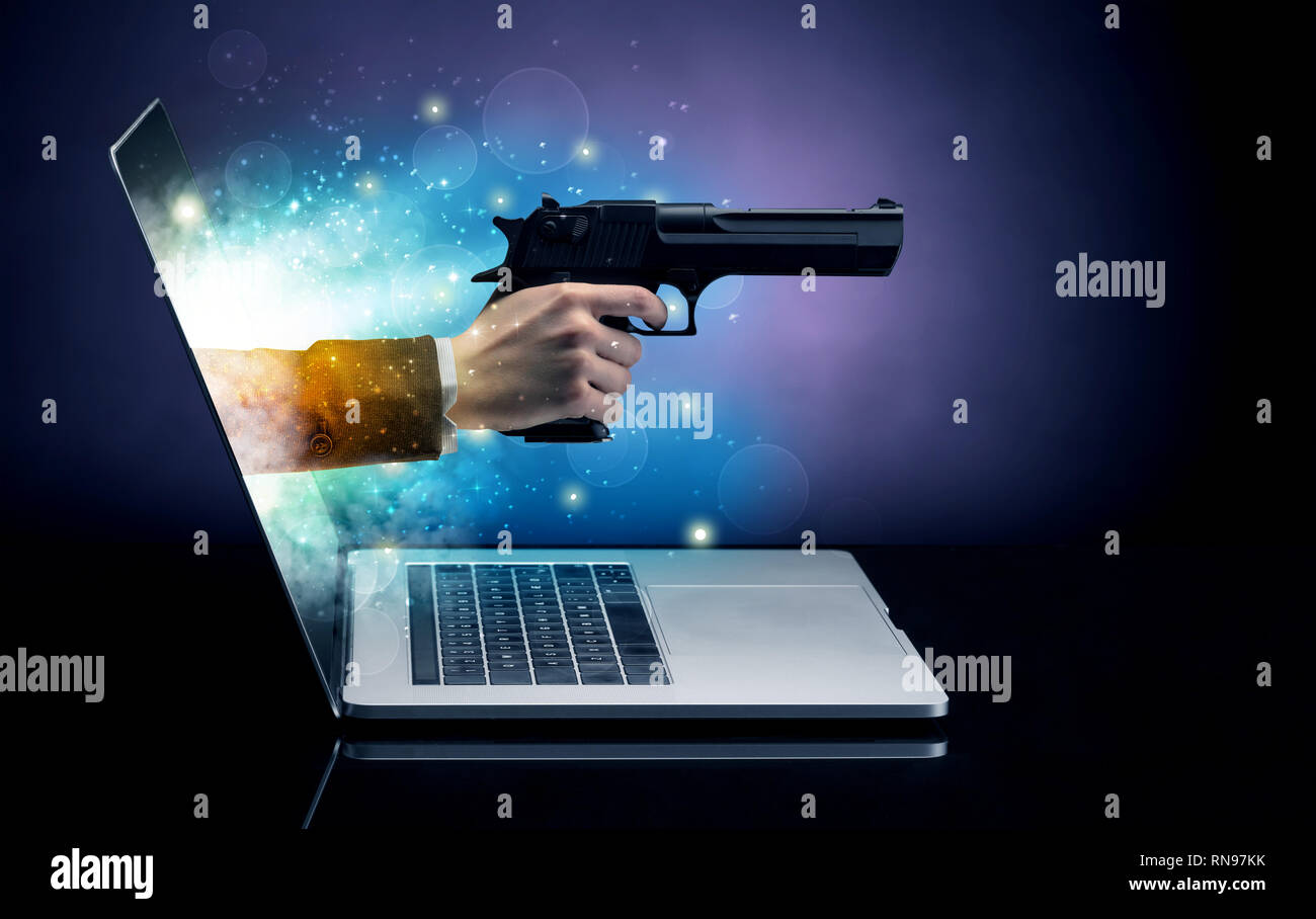 Hand mit Gewehr aus einem Laptop mit funkelnden Effekten Stockfoto