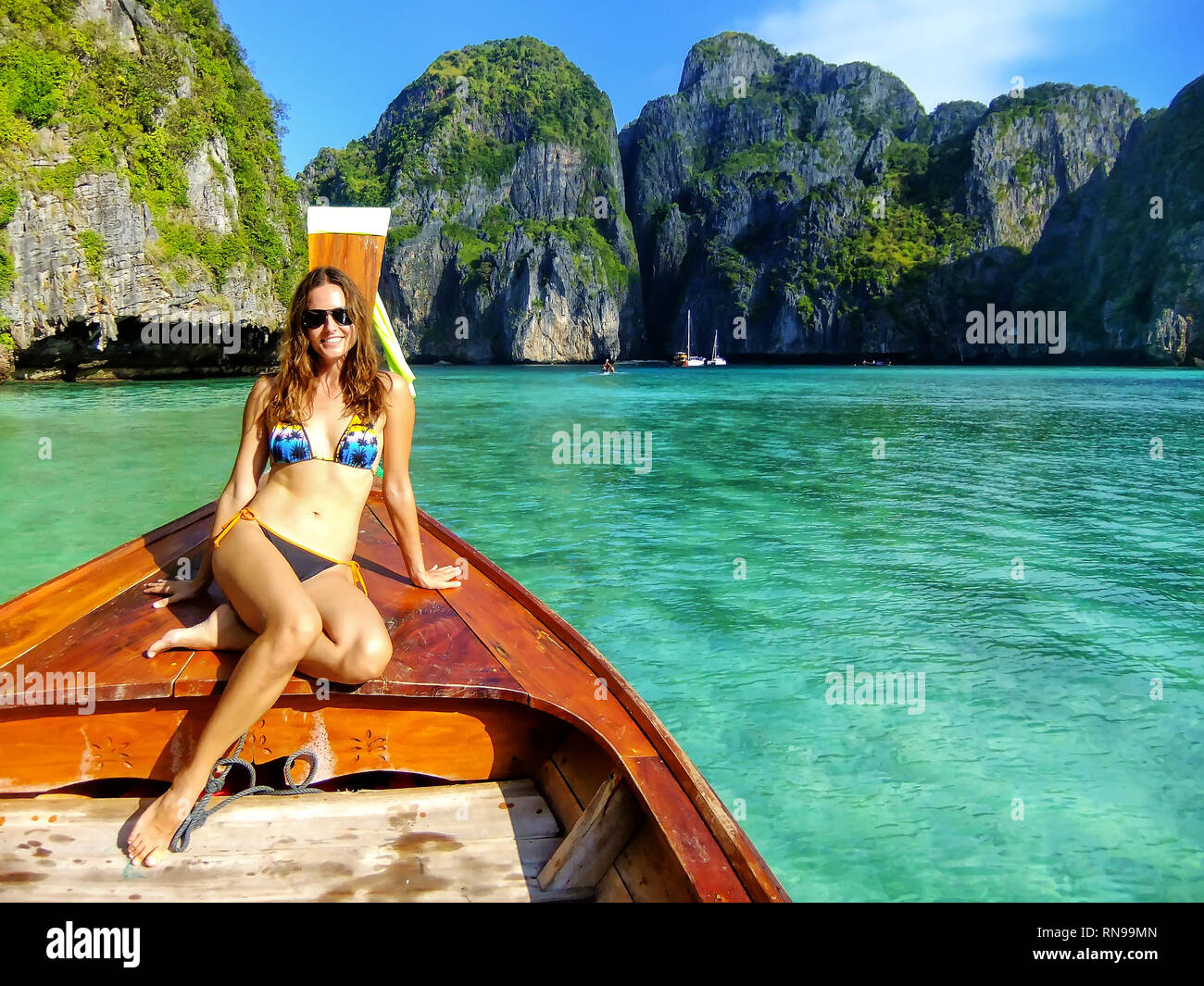 Junge Frau sitzt an der Vorderseite des Longtail-Boot in der Maya Bay auf Phi Phi Leh Island, Provinz Krabi, Thailand. Phi Phi Leh ist Teil des Mu Ko Phi Phi Na Stockfoto